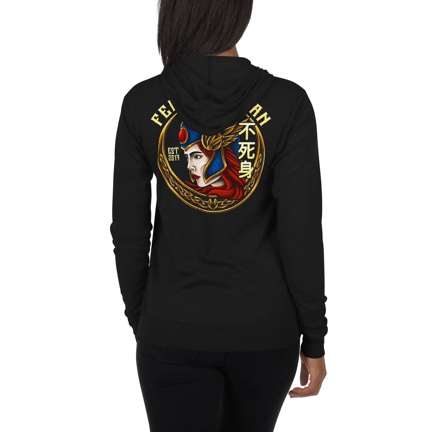 A young African American women wearing a black zip up hoodie. The back of the hoodie is showing with The Valkyrie design on it by The Immortal Society.