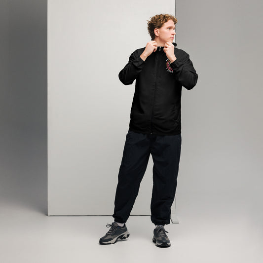 A man posing with a black jacket with The Immortal Society logo in the front. 
