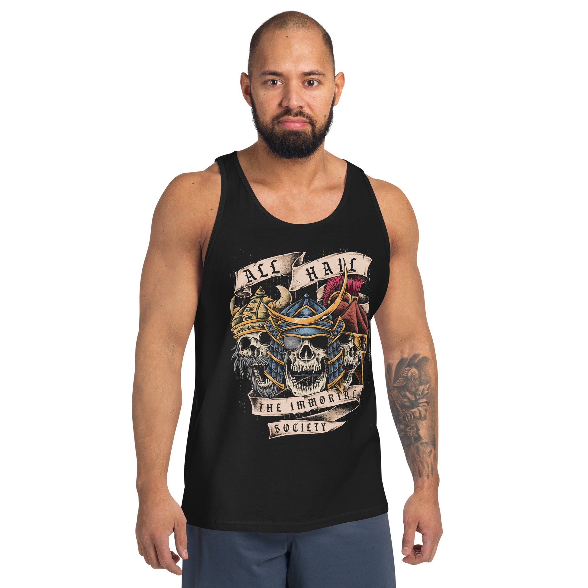 A man with a shaved head and beard wearing a black colored tank top with The Immortal Warriors design on it. He is standing in front of a white background. 