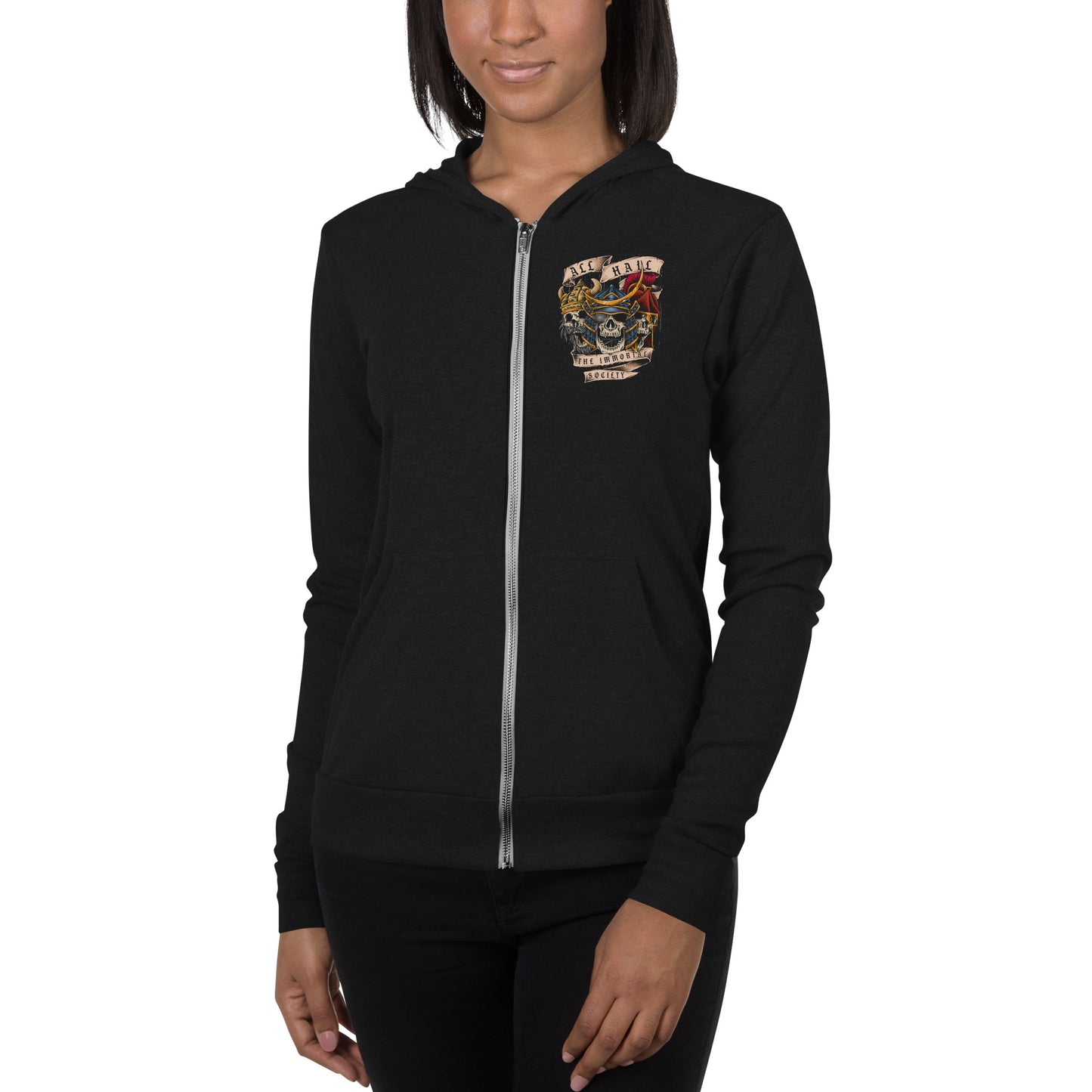 A young African American women wearing a black zip up hoodie. The front left side of the hoodie has a small design with The Immortal Warriors on it.  