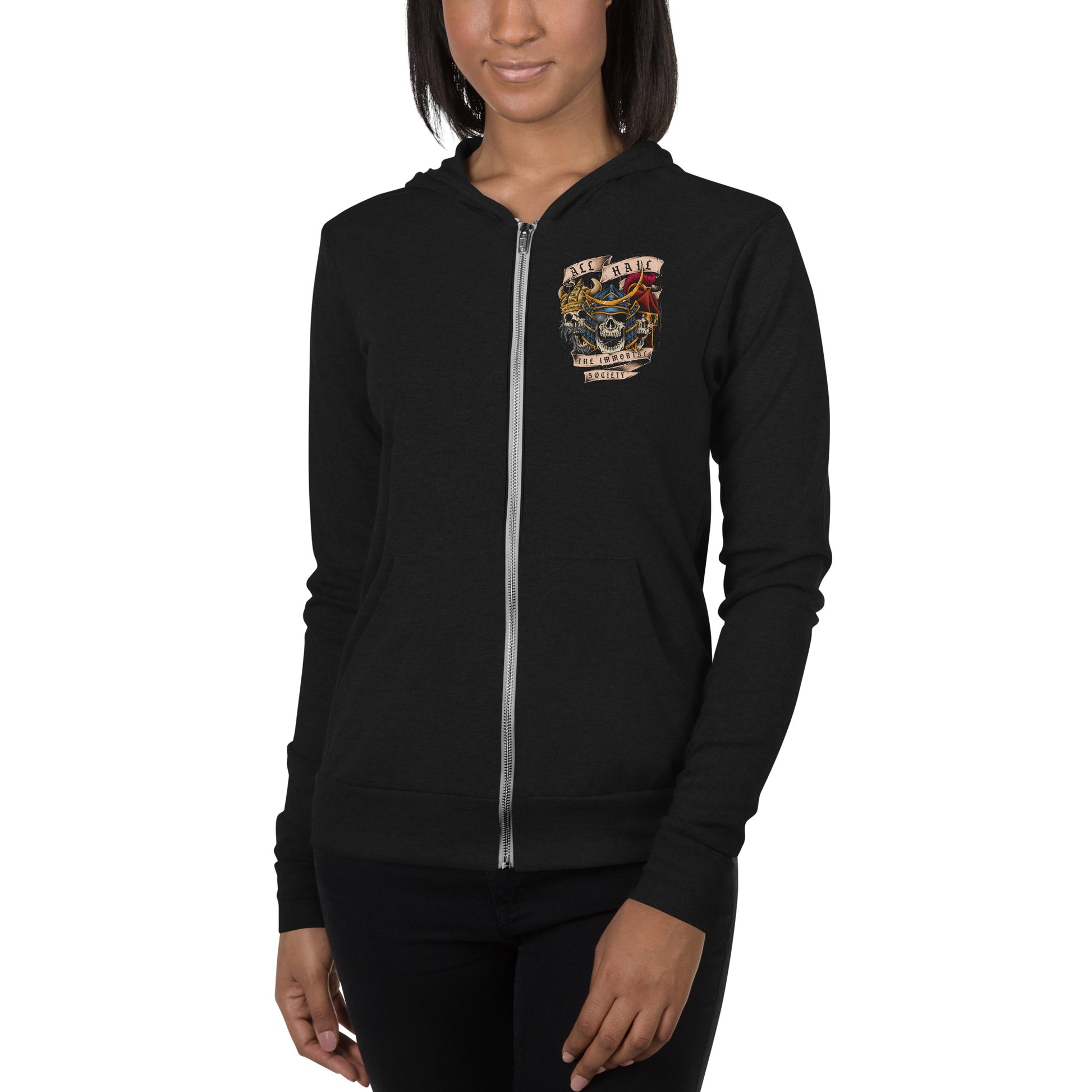 A young African American women wearing a black zip up hoodie. The front left side of the hoodie has a small design with The Immortal Warriors on it.  